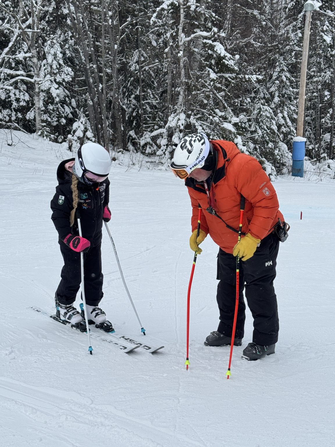 Coach speaking with a young athlete on snow