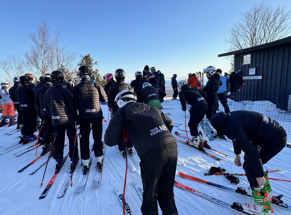 Coach and young athletes gathered on a ski hill