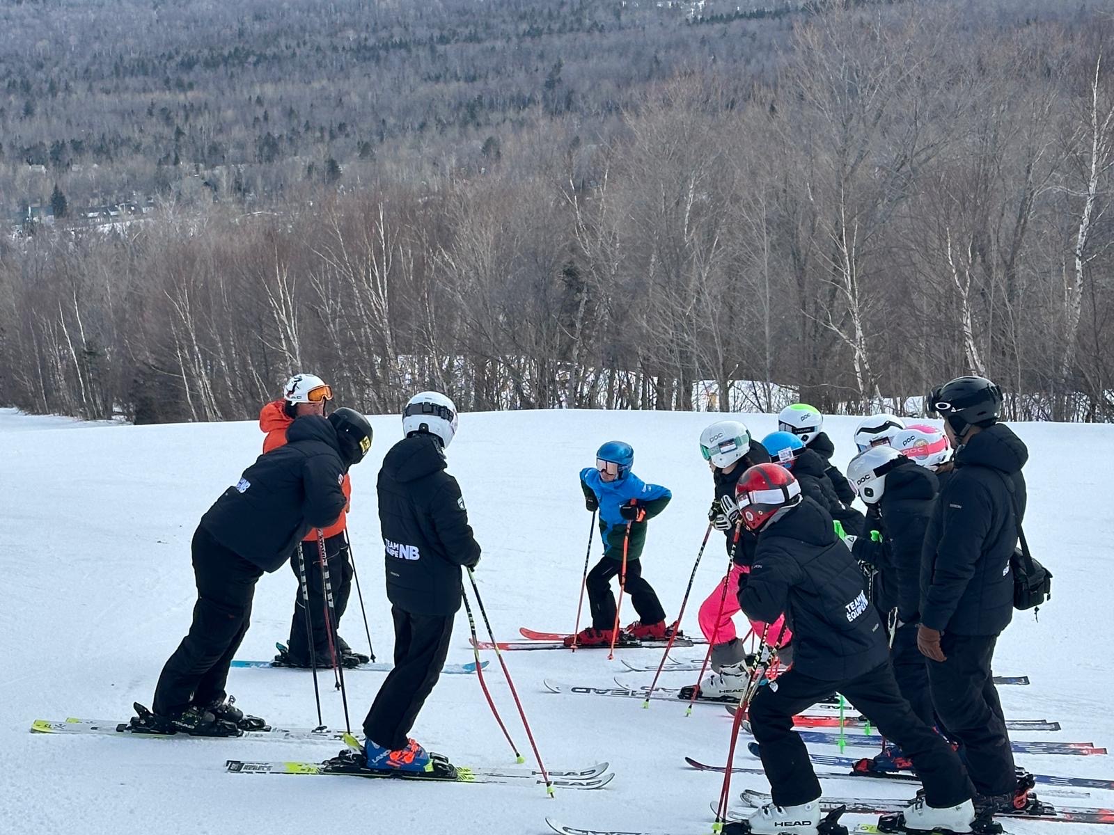 Coach working with a group of young athletes on snow